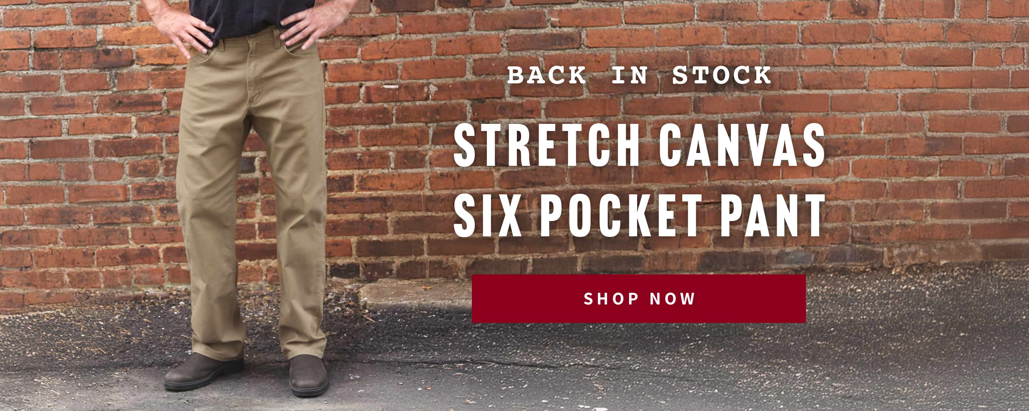 Person wearing a stretch canvas six pocket pant in front of a brick wall with promotional text.